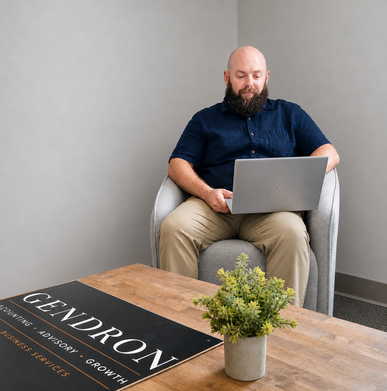 Ryan Gendron working with a laptop in a professional office setting